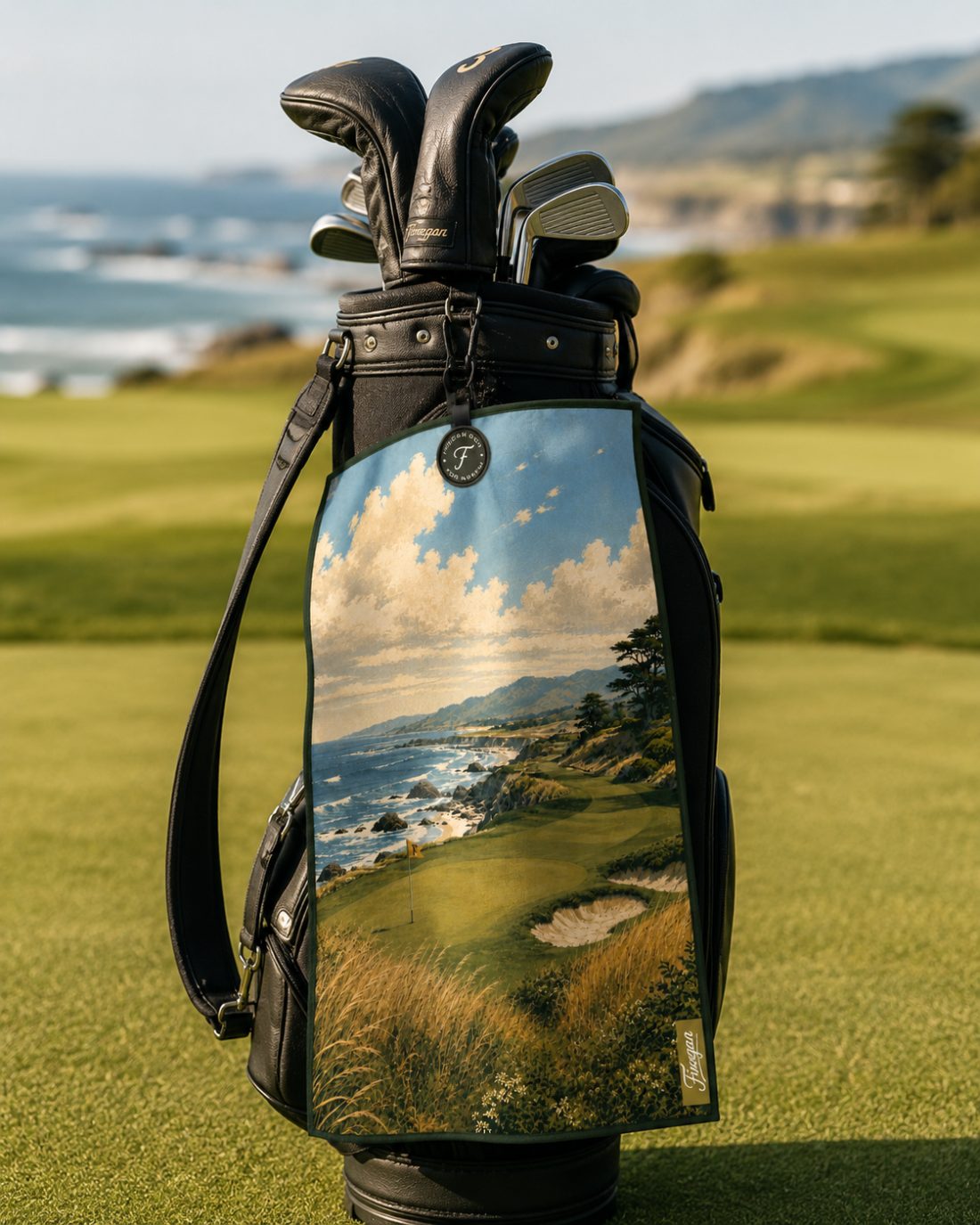 The Cliffs towel clipped to a black leather golf bag on a coastal fairway